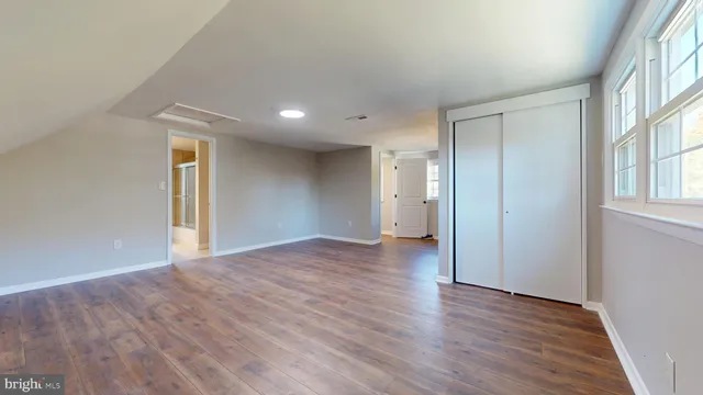 a view of empty room with wooden floor