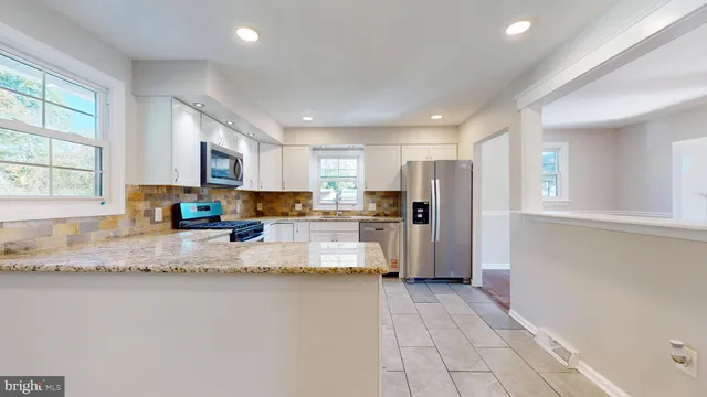 a kitchen with stainless steel appliances granite countertop a refrigerator sink and cabinets