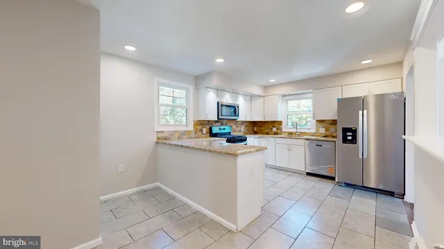 a kitchen with white cabinets and white appliances