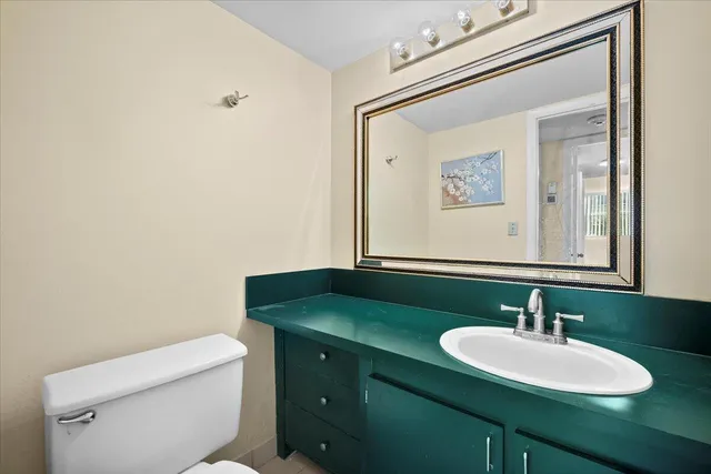 a bathroom with a toilet sink and mirror