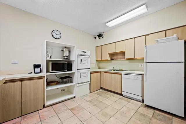 a kitchen with granite countertop cabinets and white appliances