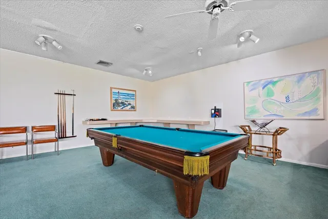 a room with pool table and windows