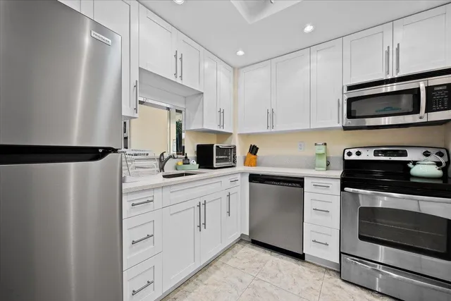 a kitchen with cabinets stainless steel appliances and sink