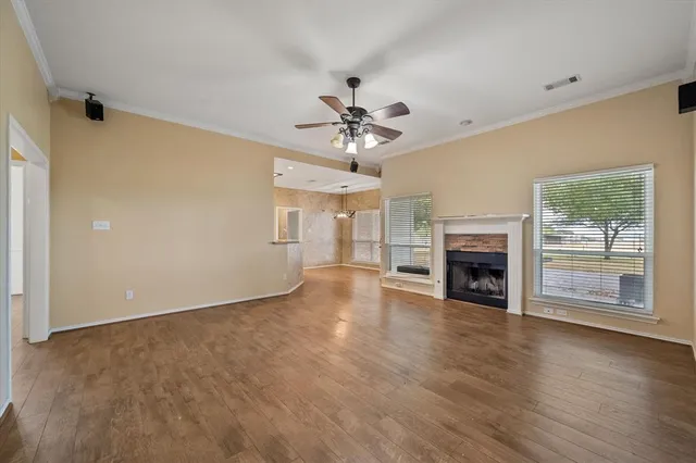 wooden floor fireplace and windows in an empty room