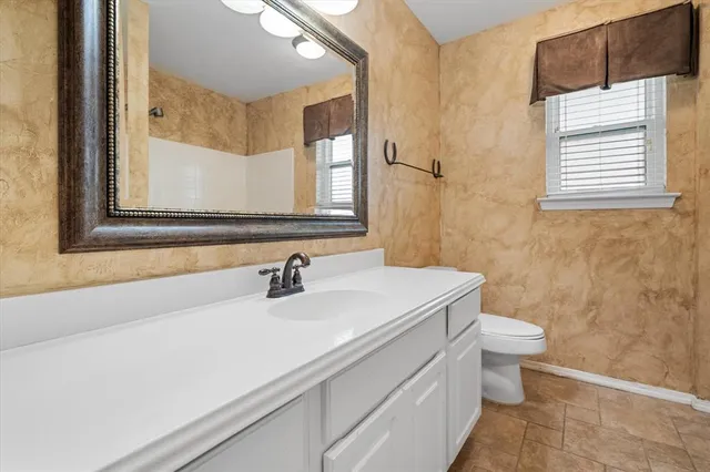 a bathroom with a sink a toilet and a mirror