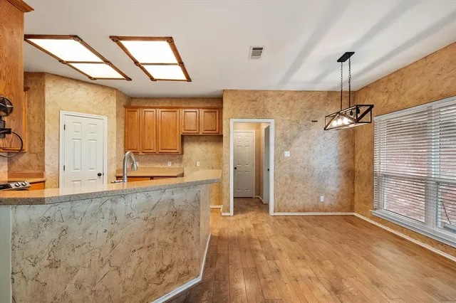 a bathroom with a granite countertop sink a mirror and shower