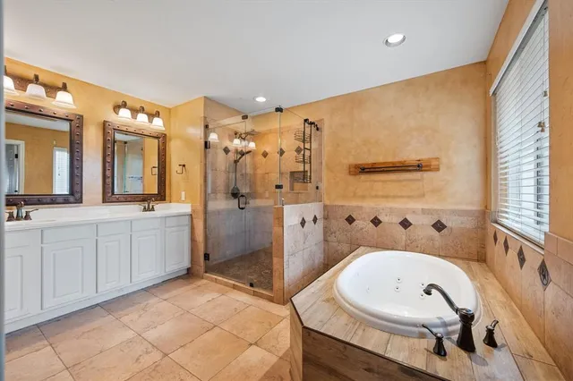 a bathroom with double vanity sinks a mirror and a shower