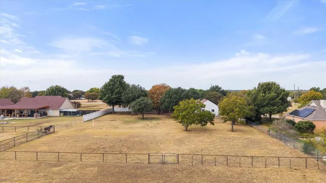 an aerial view of a house with a yard and lake view