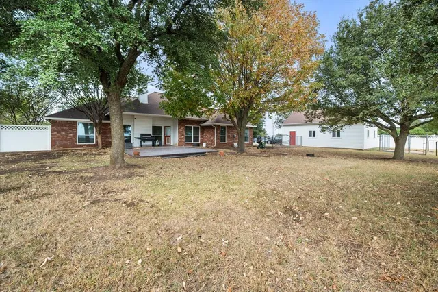 a front view of a house with a yard and large trees