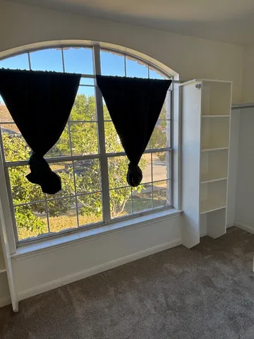 a view of a livingroom with a ceiling fan and window