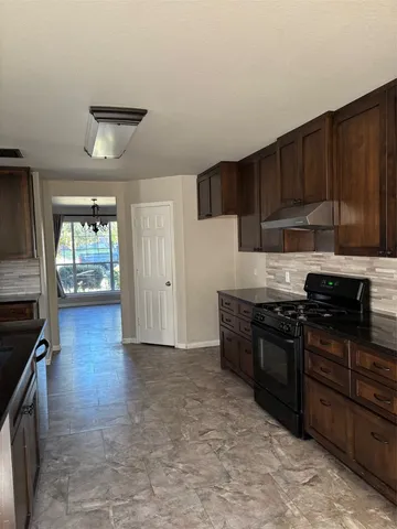 a kitchen with stainless steel appliances granite countertop a stove sink and cabinets