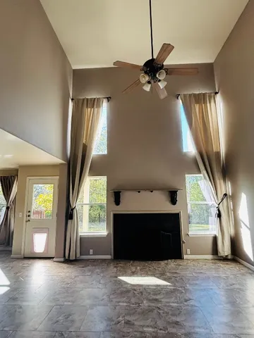 a view of an empty room with a fireplace and a window