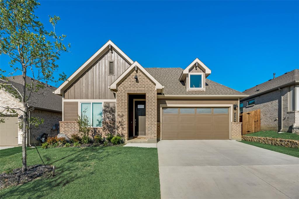 View of front of home featuring a front lawn and a garage