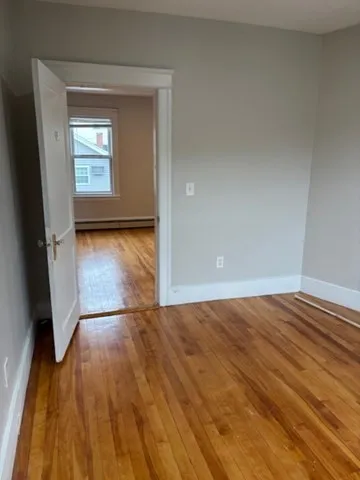 a kitchen with a refrigerator a stove top oven and white cabinets with wooden floor