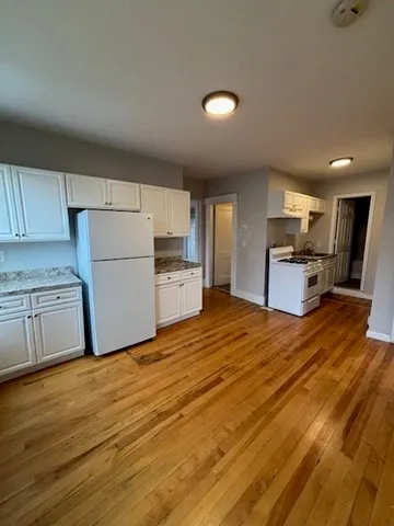 a kitchen with granite countertop a refrigerator and a stove top oven