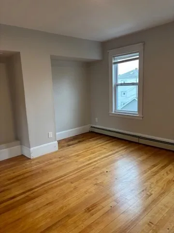 a view of empty room with wooden floor