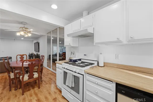 a kitchen with granite countertop a stove chairs and a dining table