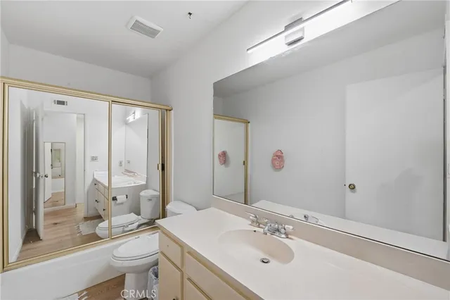 a bathroom with a granite countertop sink toilet a large mirror and shower