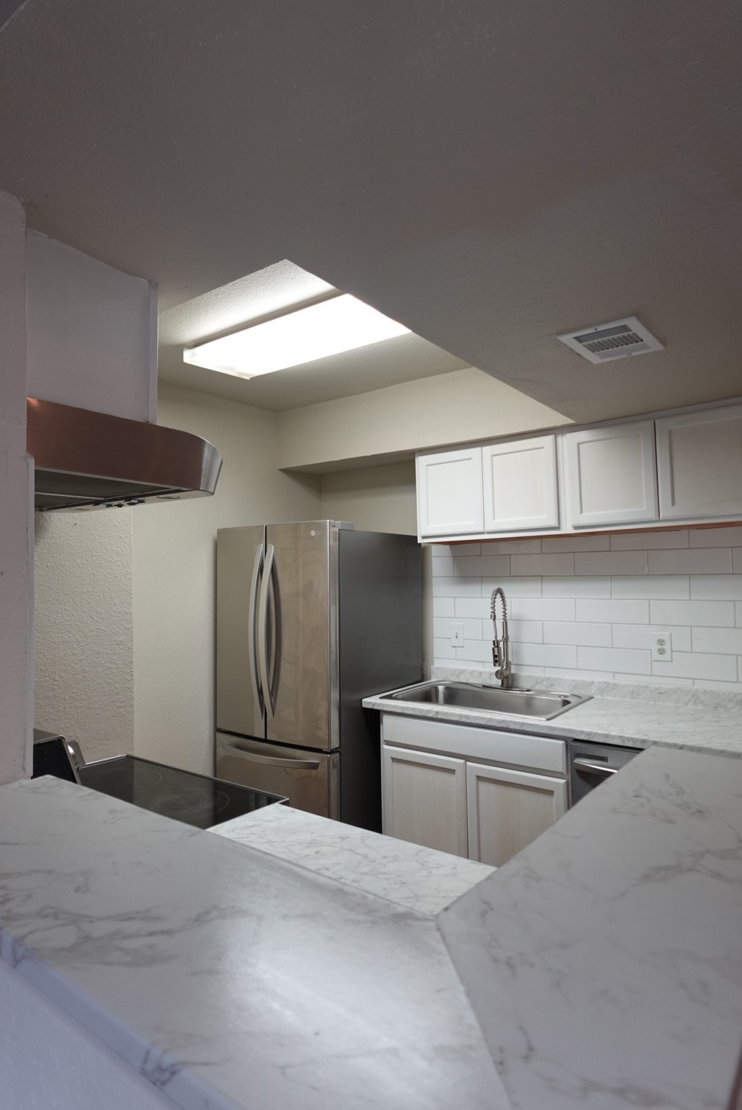 6001 Reims Road, Unit 1207 Houston, TX 77036 - Photo 21 of 36 a kitchen with stainless steel appliances a sink dishwasher a refrigerator and cabinets with wooden floor