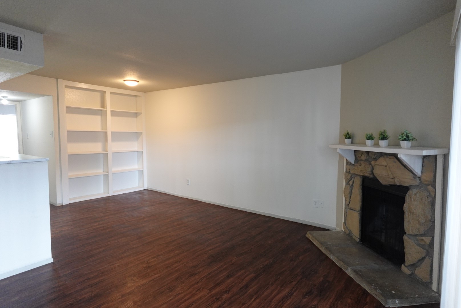 6001 Reims Road, Unit 1207 Houston, TX 77036 - Photo 5 of 36 a view of an empty room with wooden floor and a fireplace