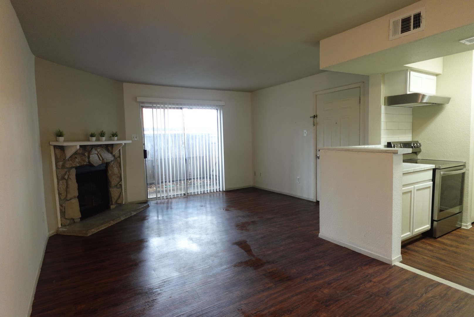 6001 Reims Road, Unit 1207 Houston, TX 77036 - Photo 8 of 36 wooden floor in an empty room with a fireplace and a window