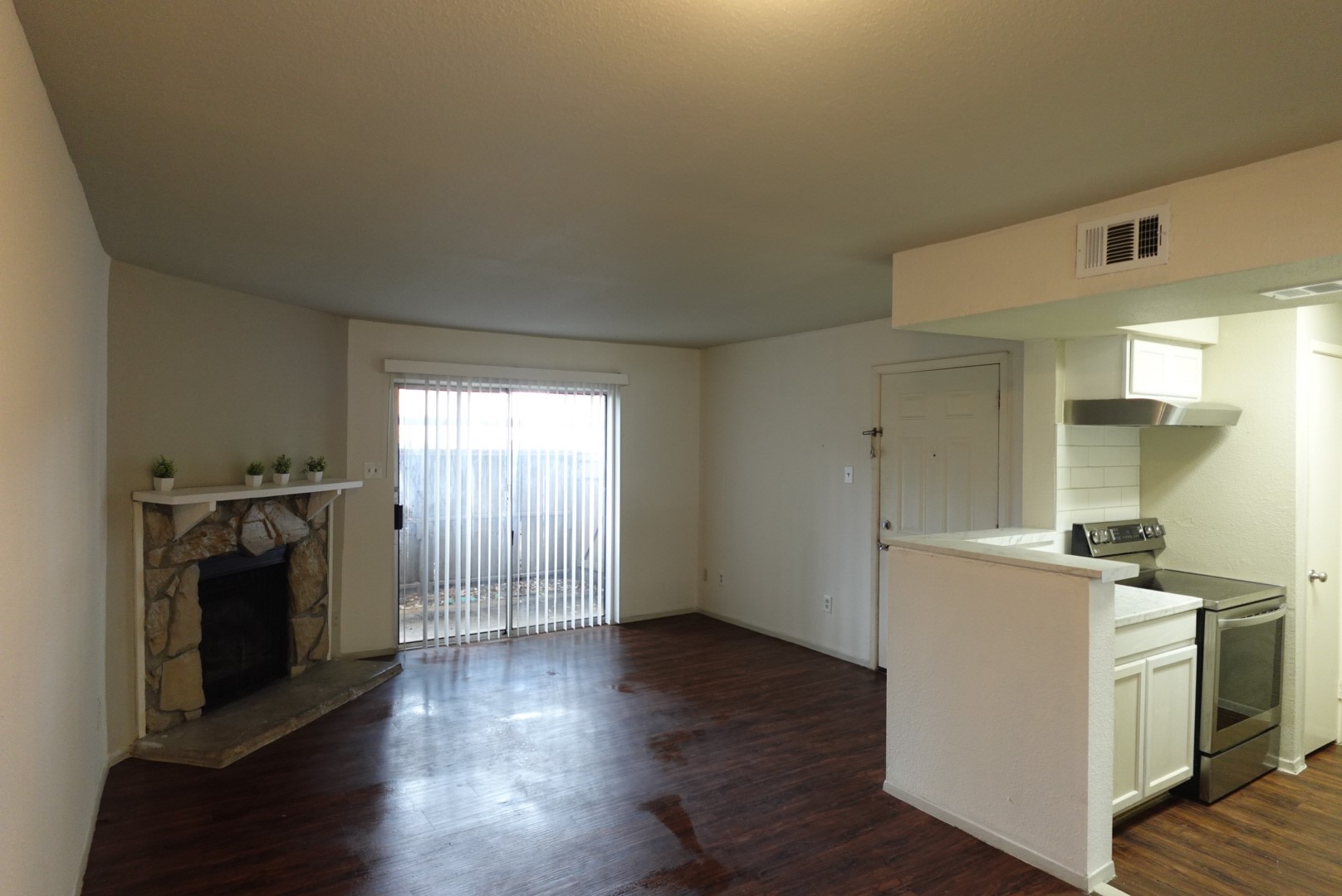 6001 Reims Road, Unit 1207 Houston, TX 77036 - Photo 9 of 36 a view of a kitchen with a stove wooden cabinets and wooden floor