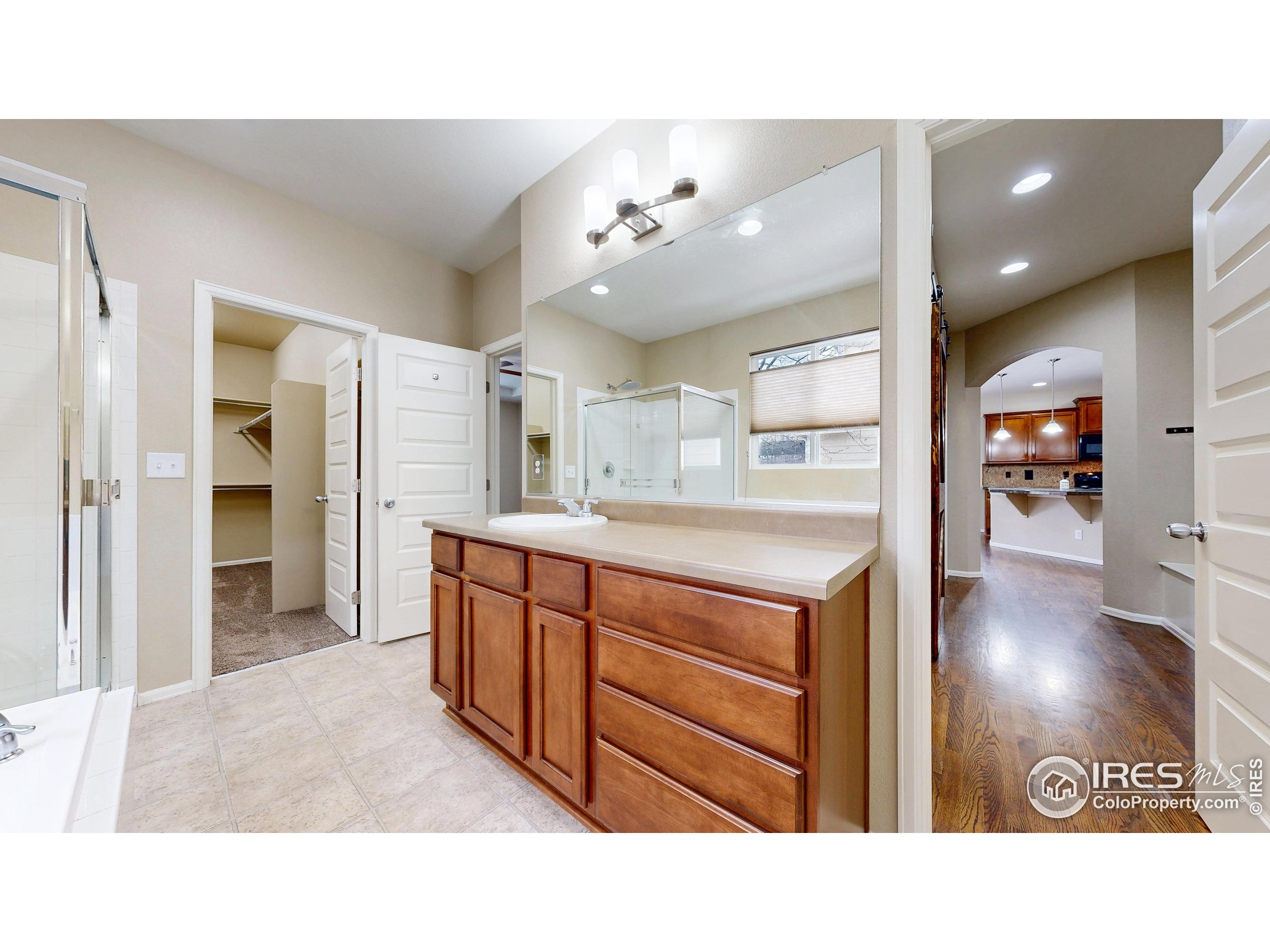 5543 Calgary Street Timnath, CO 80547 - Photo 13 of 38 a bathroom with a sink a vanity and a large mirror
