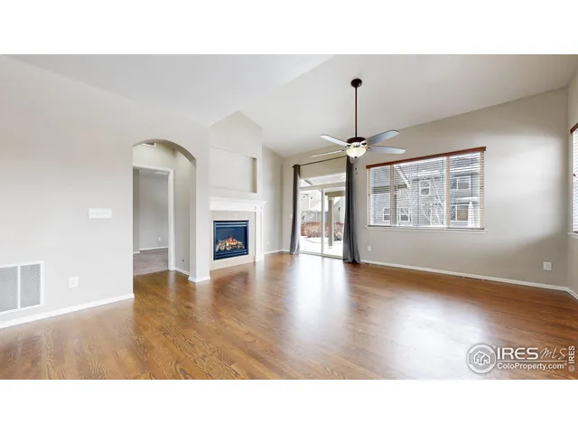 a open hall with a fireplace and wooden floor
