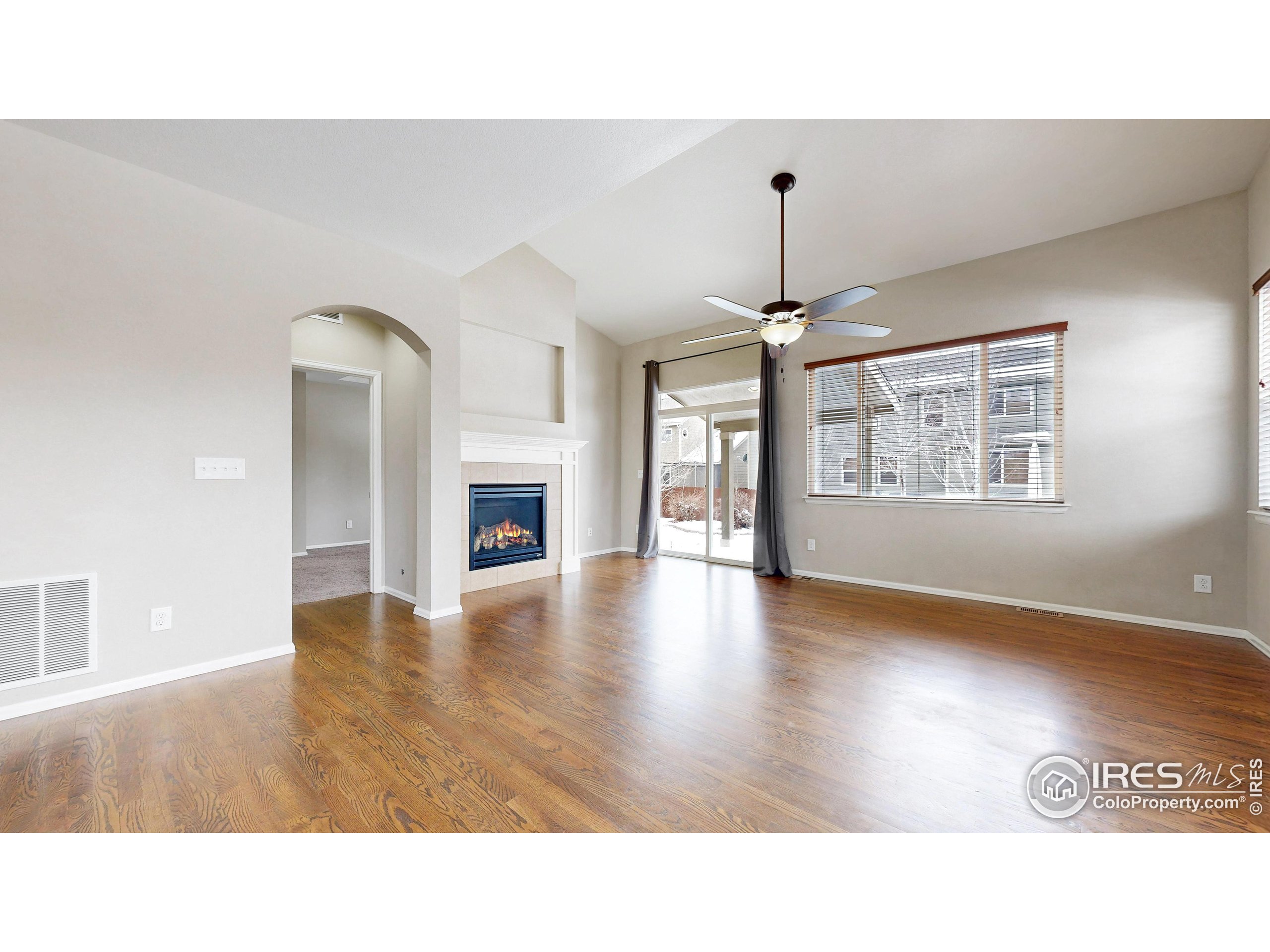 5543 Calgary Street Timnath, CO 80547 - Photo 2 of 38 a open hall with a fireplace and wooden floor