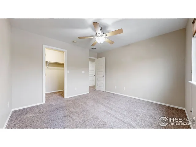 a open hall with a ceiling fan and a window