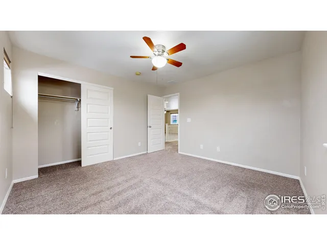 a open hall with a ceiling fan a window and a ceiling fan