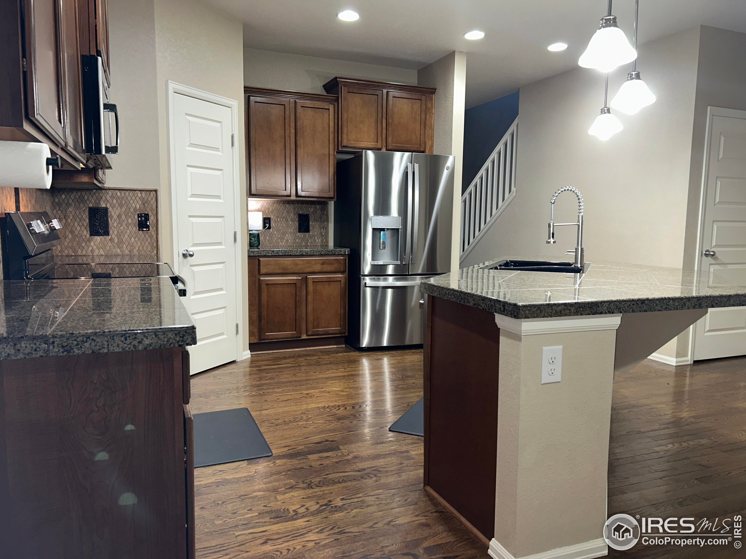 5543 Calgary Street Timnath, CO 80547 - Photo 6 of 38 a kitchen with stainless steel appliances granite countertop a refrigerator and a sink