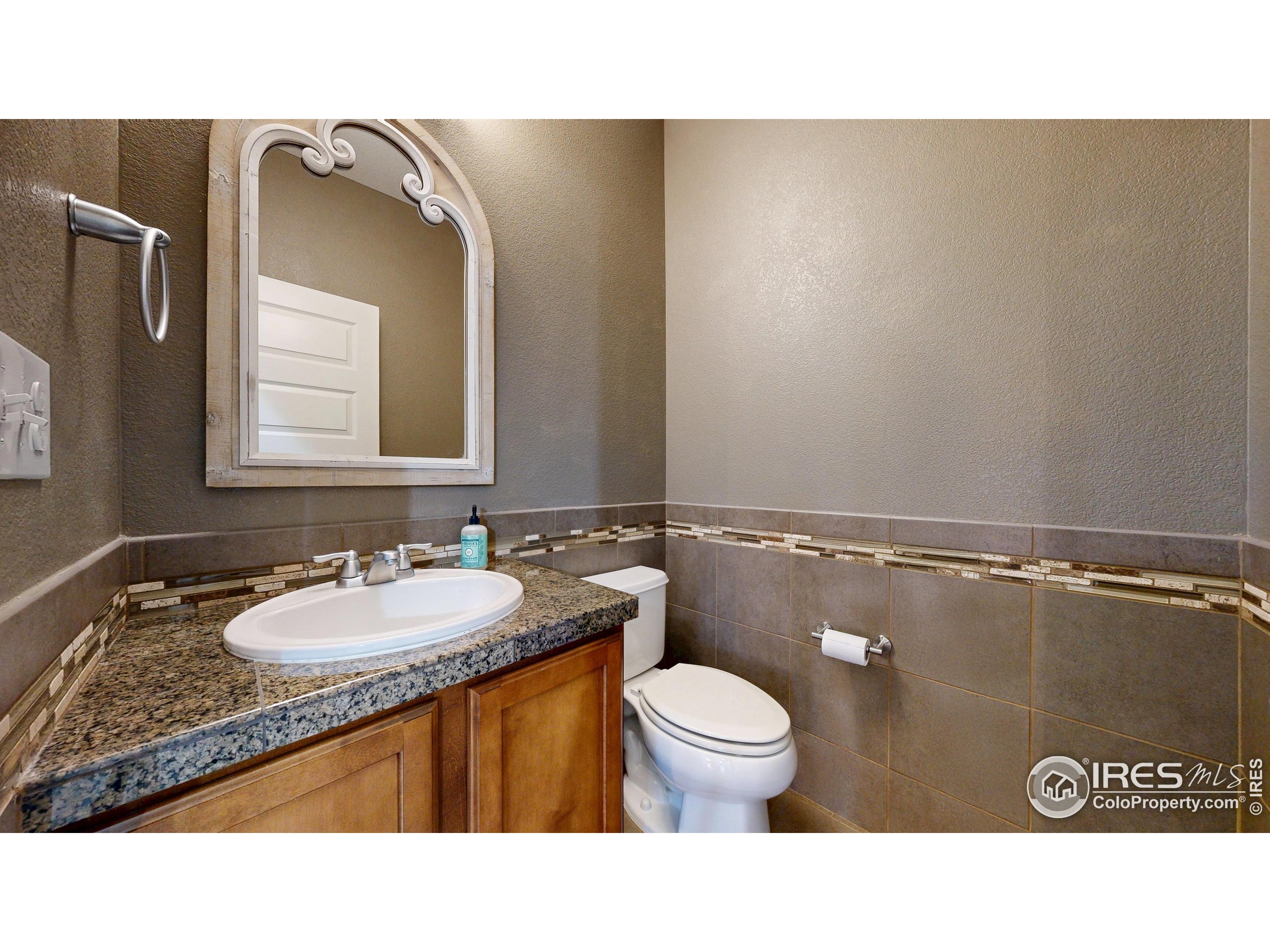 5543 Calgary Street Timnath, CO 80547 - Photo 9 of 38 a bathroom with a sink a toilet and mirror