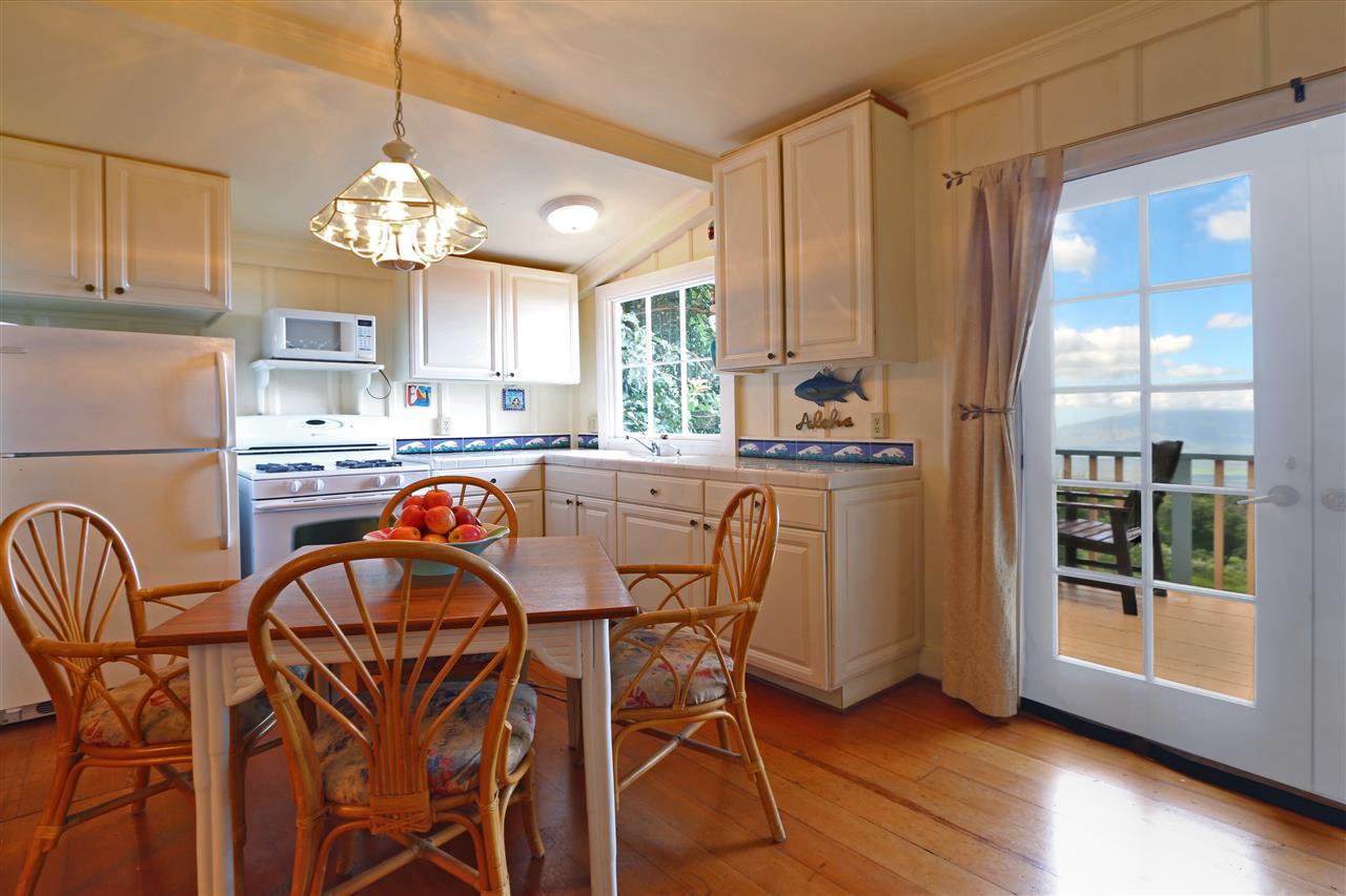 5231 Lower Kula Road Kula, HI 96790 - Photo 18 of 29 a kitchen with stainless steel appliances a table chairs and chandelier