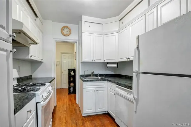 a kitchen with stainless steel appliances granite countertop a refrigerator a stove and a sink