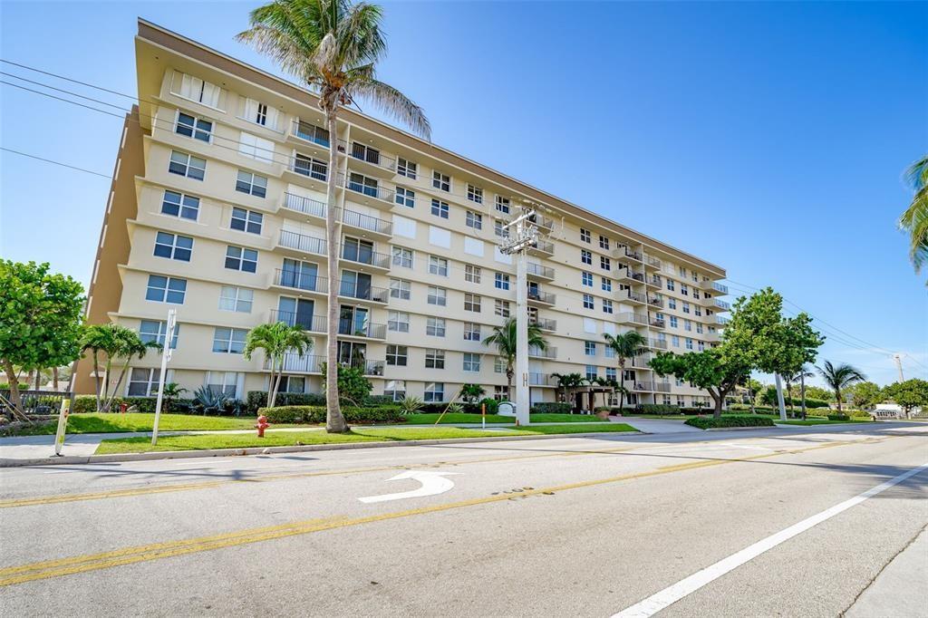 1009 North Ocean Boulevard, Unit 407 Pompano Beach, FL 33062 - Photo 1 of 35 a view of a tall building next to a yard