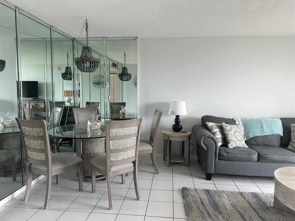 1009 North Ocean Boulevard, Unit 407 Pompano Beach, FL 33062 - Photo 11 of 35 a living room with couches a fireplace and kitchen view with wooden floor