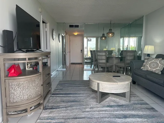 a bedroom with a bed and a large mirror next to a window