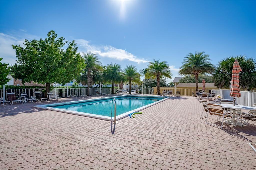 1009 North Ocean Boulevard, Unit 407 Pompano Beach, FL 33062 - Photo 21 of 35 a view of a swimming pool with a chair and tables
