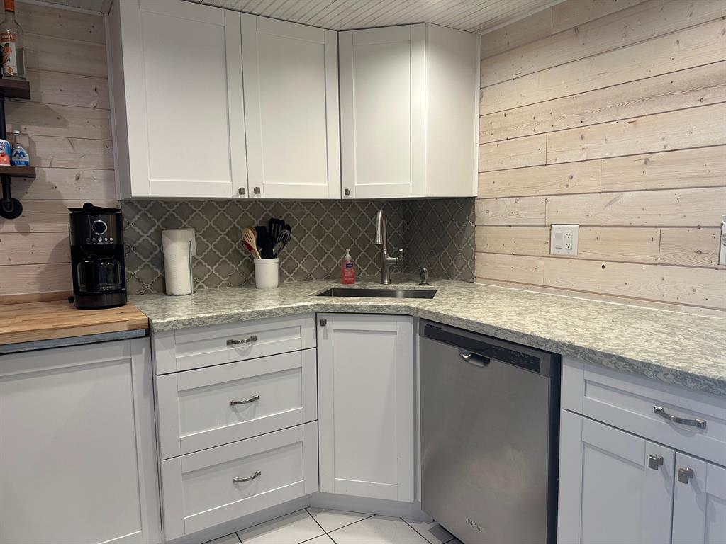 1009 North Ocean Boulevard, Unit 407 Pompano Beach, FL 33062 - Photo 5 of 35 a kitchen with granite countertop white cabinets and a sink