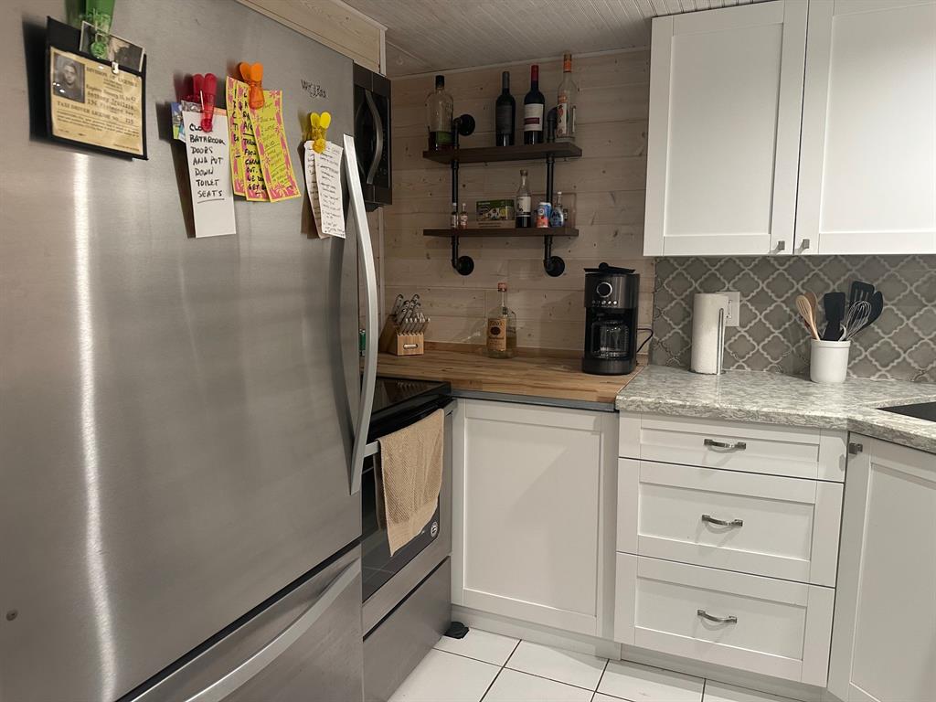 1009 North Ocean Boulevard, Unit 407 Pompano Beach, FL 33062 - Photo 7 of 35 a kitchen with stainless steel appliances granite countertop cabinets and a refrigerator