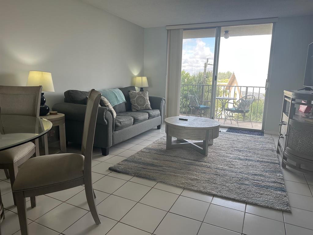 1009 North Ocean Boulevard, Unit 407 Pompano Beach, FL 33062 - Photo 10 of 35 a living room with furniture and a fireplace