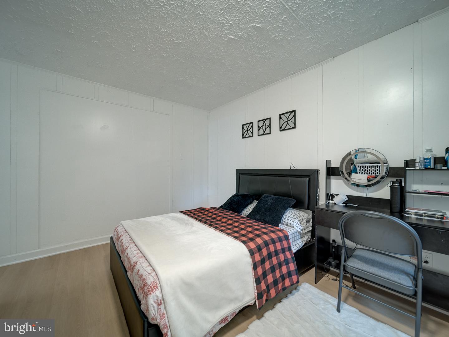 10397 Blue Arrow Court Columbia, MD 21044 - Photo 11 of 43 a bed sitting in a bedroom next to a lamp with wooden floor