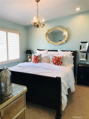 a bedroom with a large bed and a chandelier