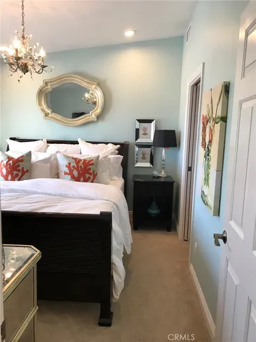 a bedroom with a bed and a chandelier