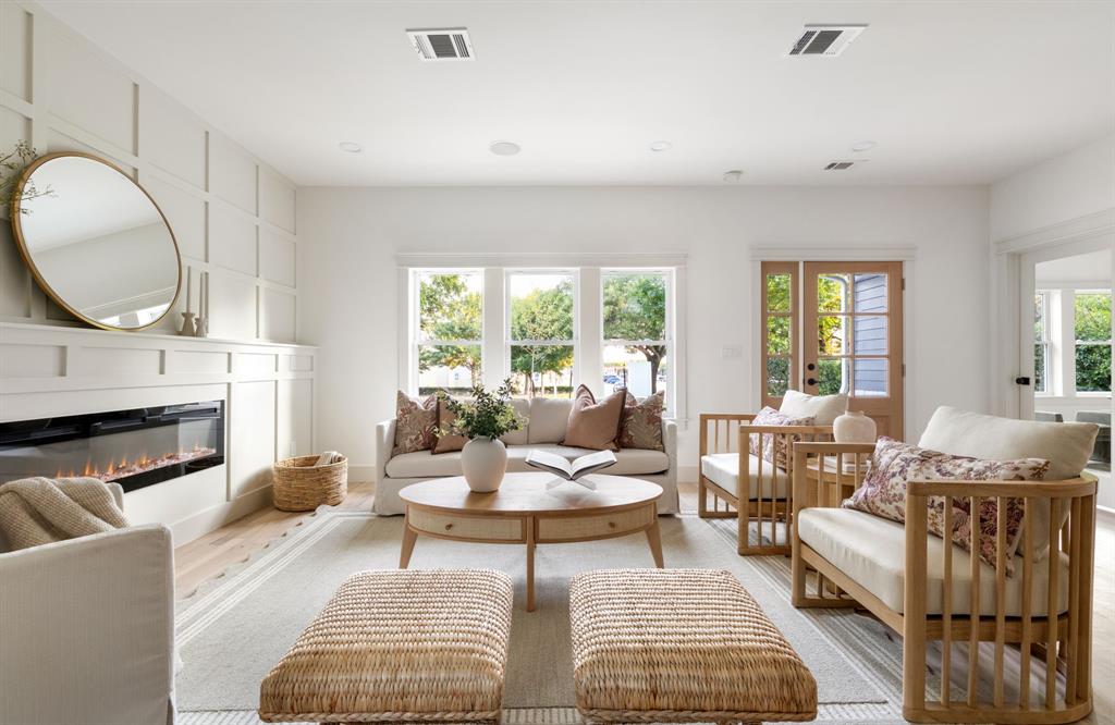 a living room with fireplace furniture and a large window