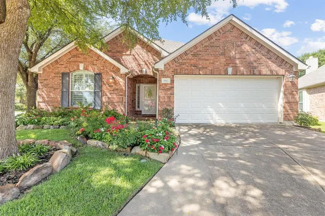a front view of a house with a yard and a garden