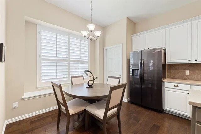 a kitchen with stainless steel appliances granite countertop white cabinets and a stove a refrigerator with wooden floor