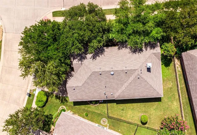a front view of a house with a garden and trees