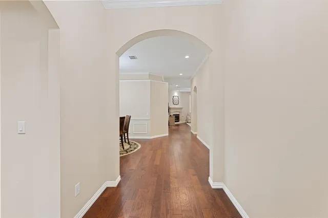 a hallway with wooden floor table and chairs